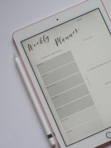 Close-up of a digital weekly planner displayed on a tablet with stylus.